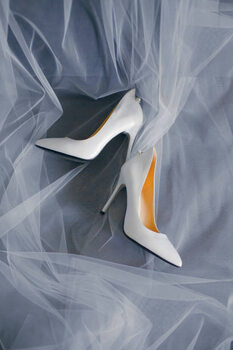 Umetniška fotografija Bride's shoes with a veil top view close-up