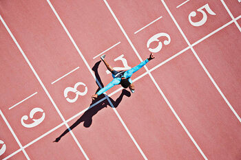 Художествена фотография Runner crossing finishing line on track