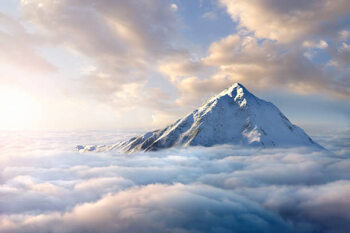 Obraz na plátne Snow-covered mountaintop above clouds