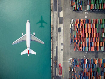Billede på lærred Airplane flying over container port