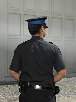 Plakat Policeman standing in street, rear view