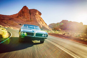 Plakát driving fast through desert in vintage hot rod car