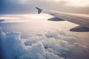 Plakát Image of airplane wing flying above the clouds