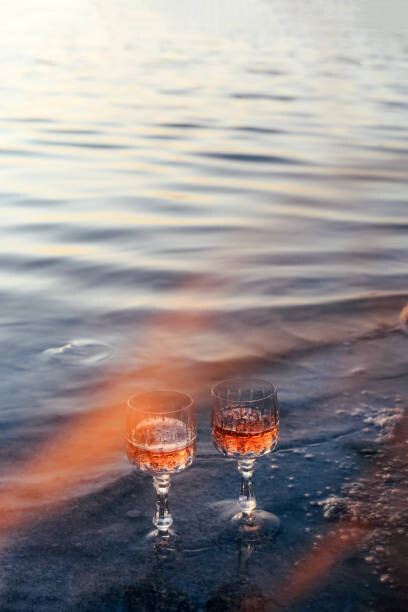 Fotografie Glasses of champagne on the beach. Alcoholic drink outdoors. Unusual drink., Maryna Terletska, 26.7 × 40 cm