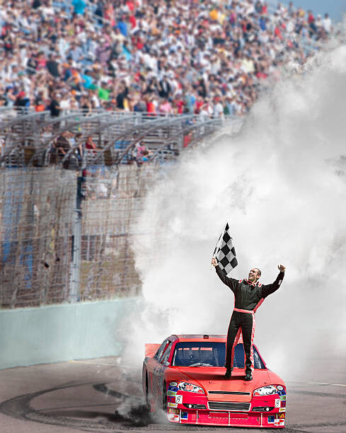 Fotografie Winning driver standing on hood of race car., Jon Feingersh, 30 × 40 cm