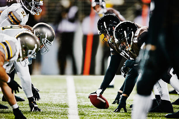 Fotografie Football teams on line of scrimmage in stadium, Thomas Barwick, 40 × 26.7 cm