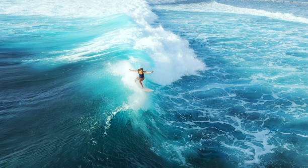 Levně Plakát, Obraz - Surfer woman riding on the blue ocean, graphixel, 40 × 22.2 cm