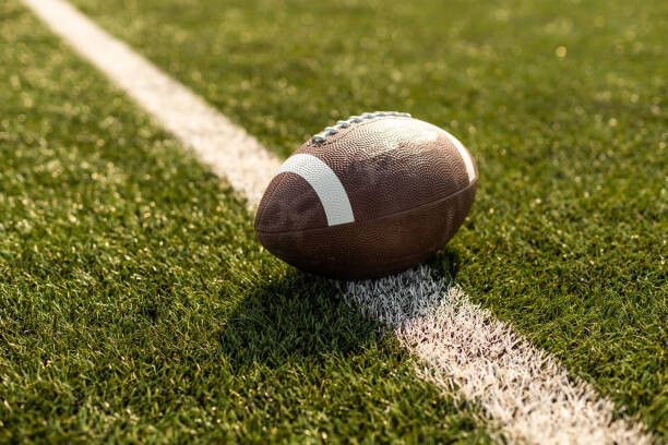 Levně Plakát, Obraz - American rugby ball on the grass in the stadium, Sinenkiy, 40 × 26.7 cm