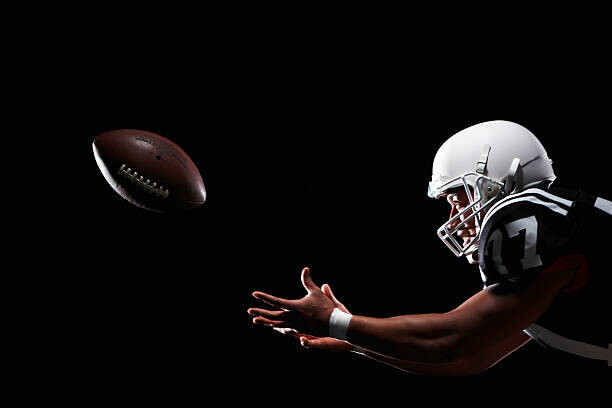 Levně Plakát, Obraz - American football player catching ball, side view, Thomas Northcut, 40 × 26.7 cm