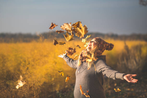 Levně Plakát, Obraz - Happy pregnant woman playing with autumn, Westend61, 40 × 26.7 cm