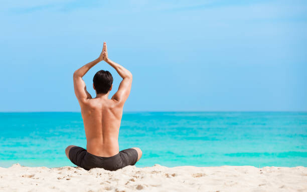 Fotografie Man meditating on the beach, kieferpix, 40 × 26.7 cm