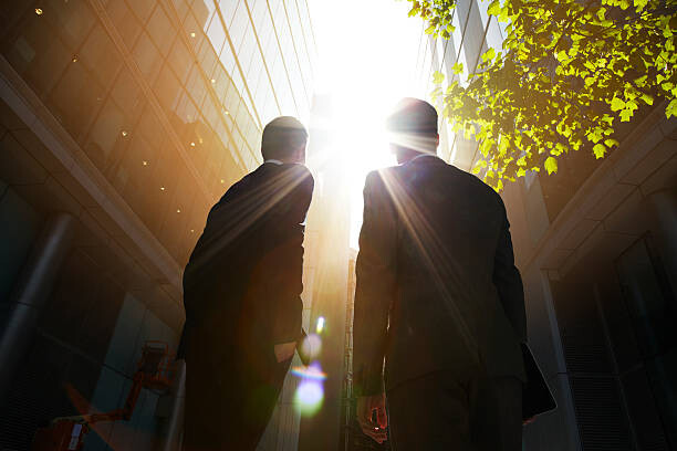 Levně Plakát, Obraz - Two businessmen looking up into the sun., Ezra Bailey, 40 × 26.7 cm