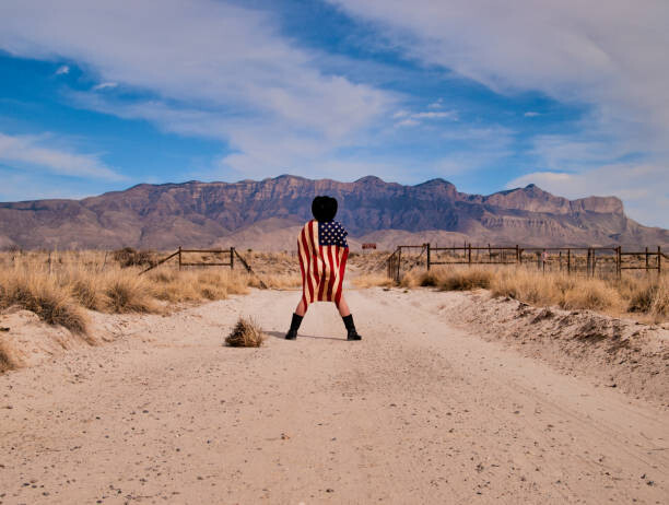 Levně Plakát, Obraz - Man Wrapped in Stained American Flag, Mark A Paulda, 40 × 30 cm