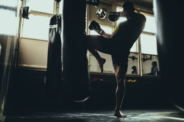 Levně Plakát, Obraz - Man kick boxer training alone in gym, South_agency, 40 × 26.7 cm