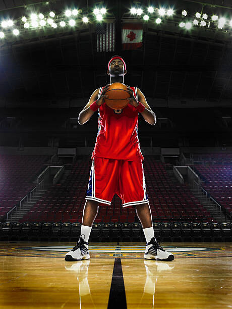 Levně Plakát, Obraz - Basketball player holding basketball, low angle, Ryan McVay, 30 × 40 cm