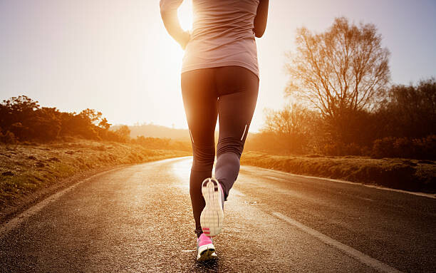 Levně Plakát, Obraz - Female runner running along road, Robert Decelis, 40 × 26.7 cm