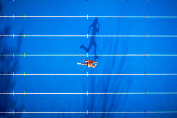 Levně Plakát, Obraz - Top view of female runner on tartan track, Westend61, 40 × 26.7 cm