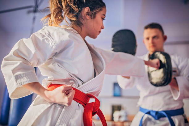 Levně Plakát, Obraz - Female karate player practicing with trainer, South_agency, 40 × 26.7 cm