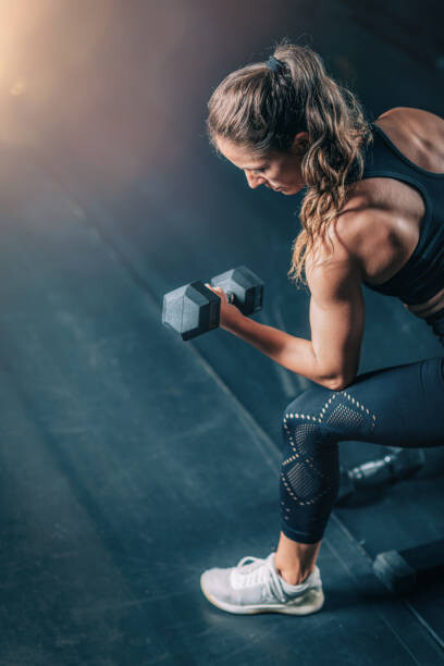 Plakát, Obraz - Female Athlete Exercising with Dumbbells in, microgen, 26.7 × 40 cm