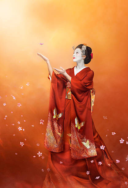 Levně Plakát, Obraz - Geisha in long red kimono catching a cherry blosso, Coneyl Jay, 26.7 × 40 cm