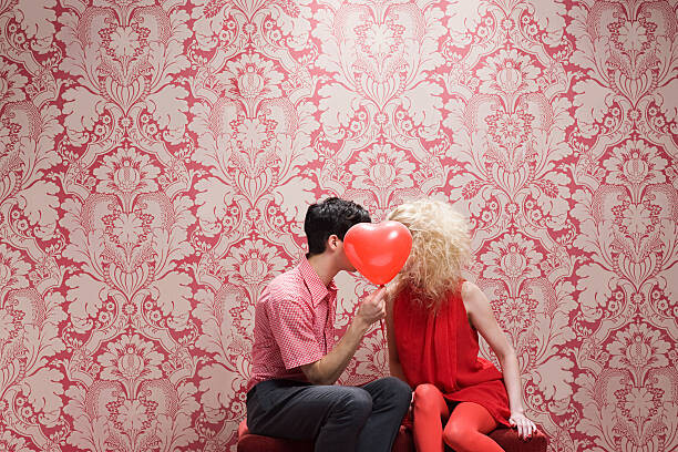 Fotografie Couple behind heart shaped balloon, Image Source, 40 × 26.7 cm