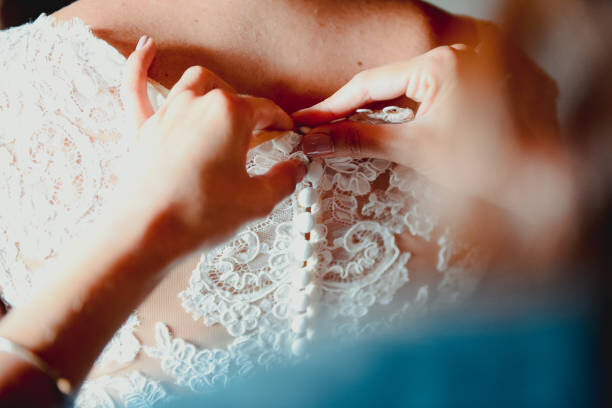 Levně Plakát, Obraz - Close-up of a bridesmaid buttoning up, corinafotografia, 40 × 26.7 cm
