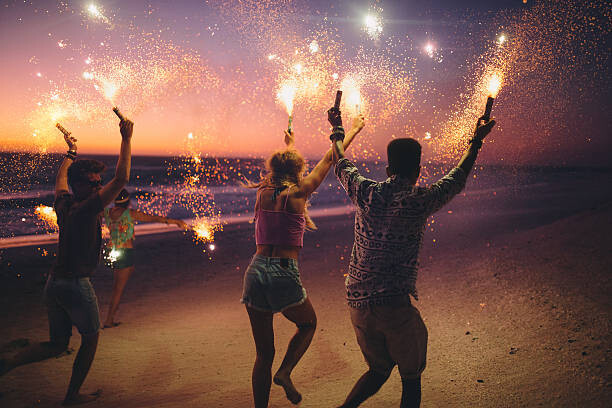 Levně Plakát, Obraz - Friends running on a beach with fireworks, wundervisuals, 40 × 26.7 cm