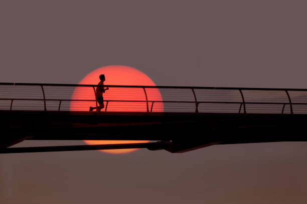 Umělecká fotografie Man out for morning run over bridge., Grant Faint, (40 x 26.7 cm)