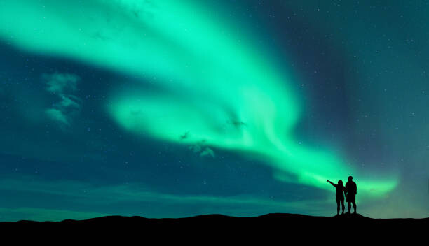 Fotografie Aurora borealis and silhouette of man and woman, den-belitsky, 40x22.5 cm