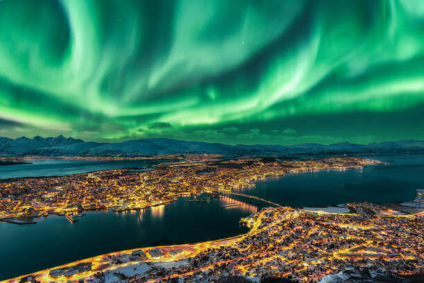 Fotografie Aurora Borealis dancing over Tromso Urban, Juan Maria Coy Vergara, 40x26.7 cm
