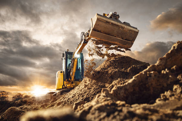 Ilustrace Excavator scooping dirt in front of a dramatic sky, photoschmidt, 40 × 26.7 cm