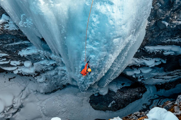 Samolepka A woman ice climbs up a