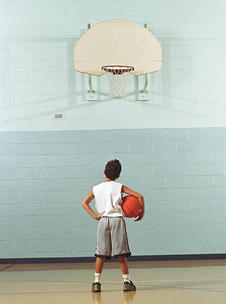 Poster Boy  holding basketball, looking at