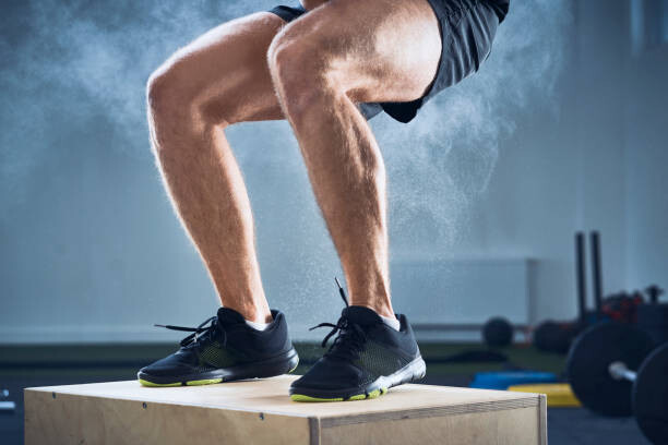 Poster Closeup of man doing box jump exercise at gym