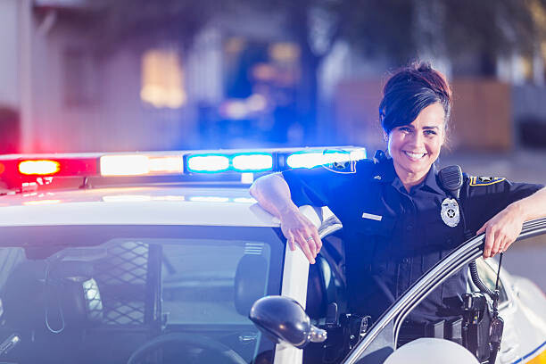 Poster Female police officer standing next to patrol car