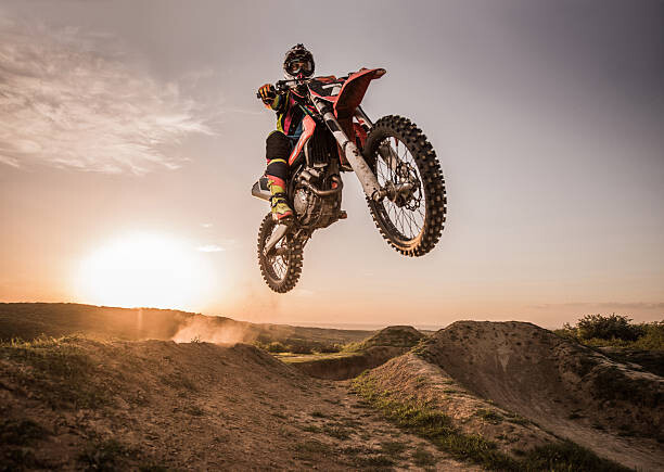Poster Motocross rider performing high jump at sunset.