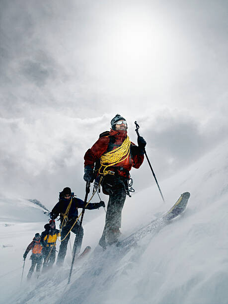 Poster Mountain climbers walking through blizzard, linked