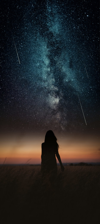 Photographie d'art Dramatic and fantasy scene with young woman looking universe with falling stars.