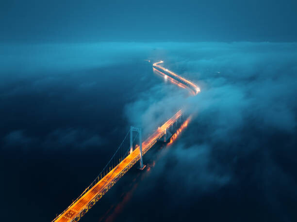 Kunstfotografie A cross-sea bridge in the fog at night