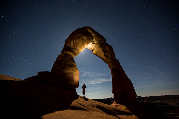 Fotografia artystyczna A hiker standing underneath an arch.
