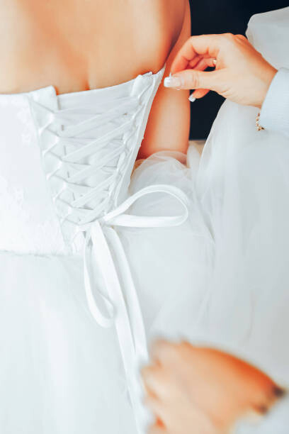 Umelecká fotografie Assistant Tie a Dress to the Bride