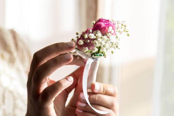 Umělecká fotografie Bride holding a buttonhole. Gentle hand