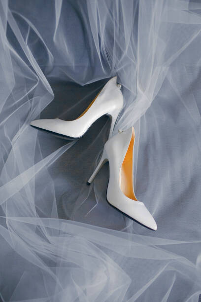 Umělecká fotografie Bride's shoes with a veil top view close-up