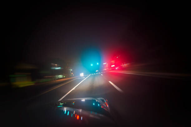 Umělecká fotografie Car driving down road with red and blue lights