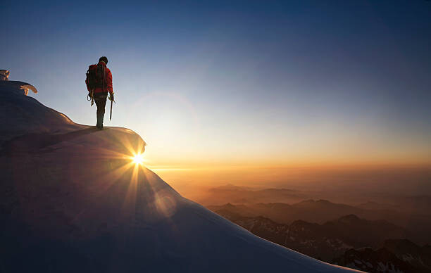 Художествена фотография Climber on a snowy range at sunset