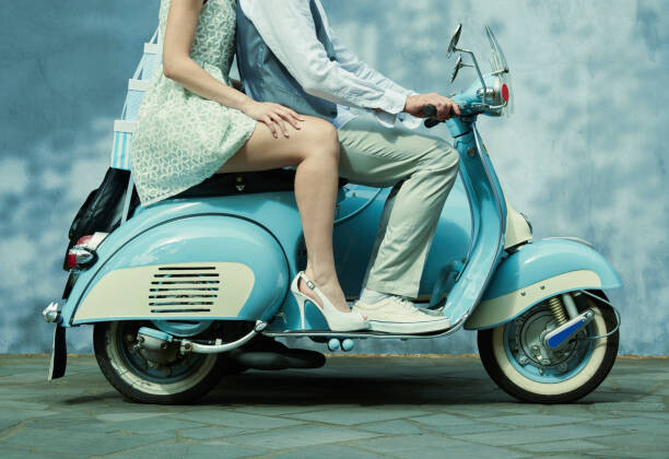 Umetniška fotografija Couple riding vintage scooter