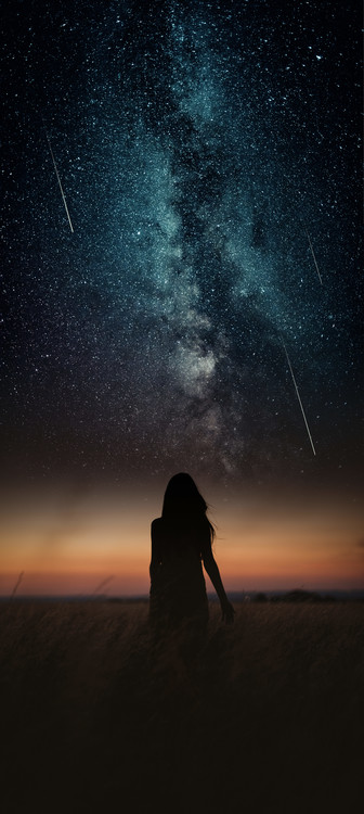 Φωτογραφία Τέχνης Dramatic and fantasy scene with young woman looking universe with falling stars.