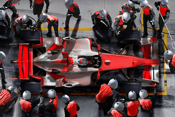 Umelecká fotografie F1 pit crew working on F1 car.