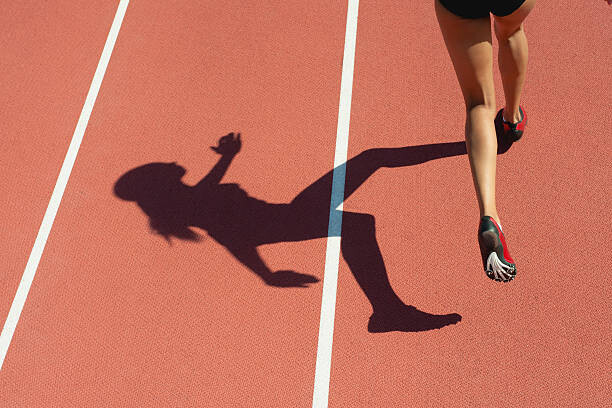 Konstfotografering Female athlete running on track, low