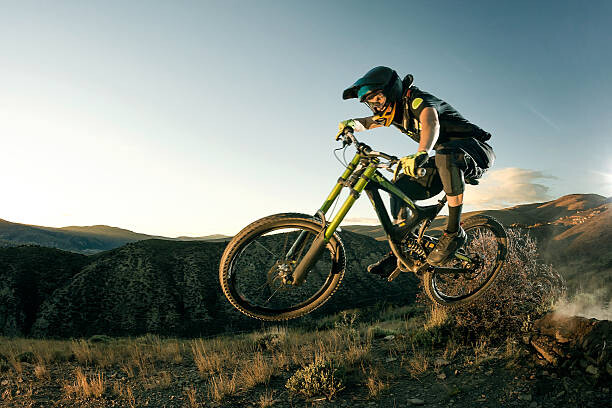 Umělecká fotografie Female biker jumping on her mountain bike.